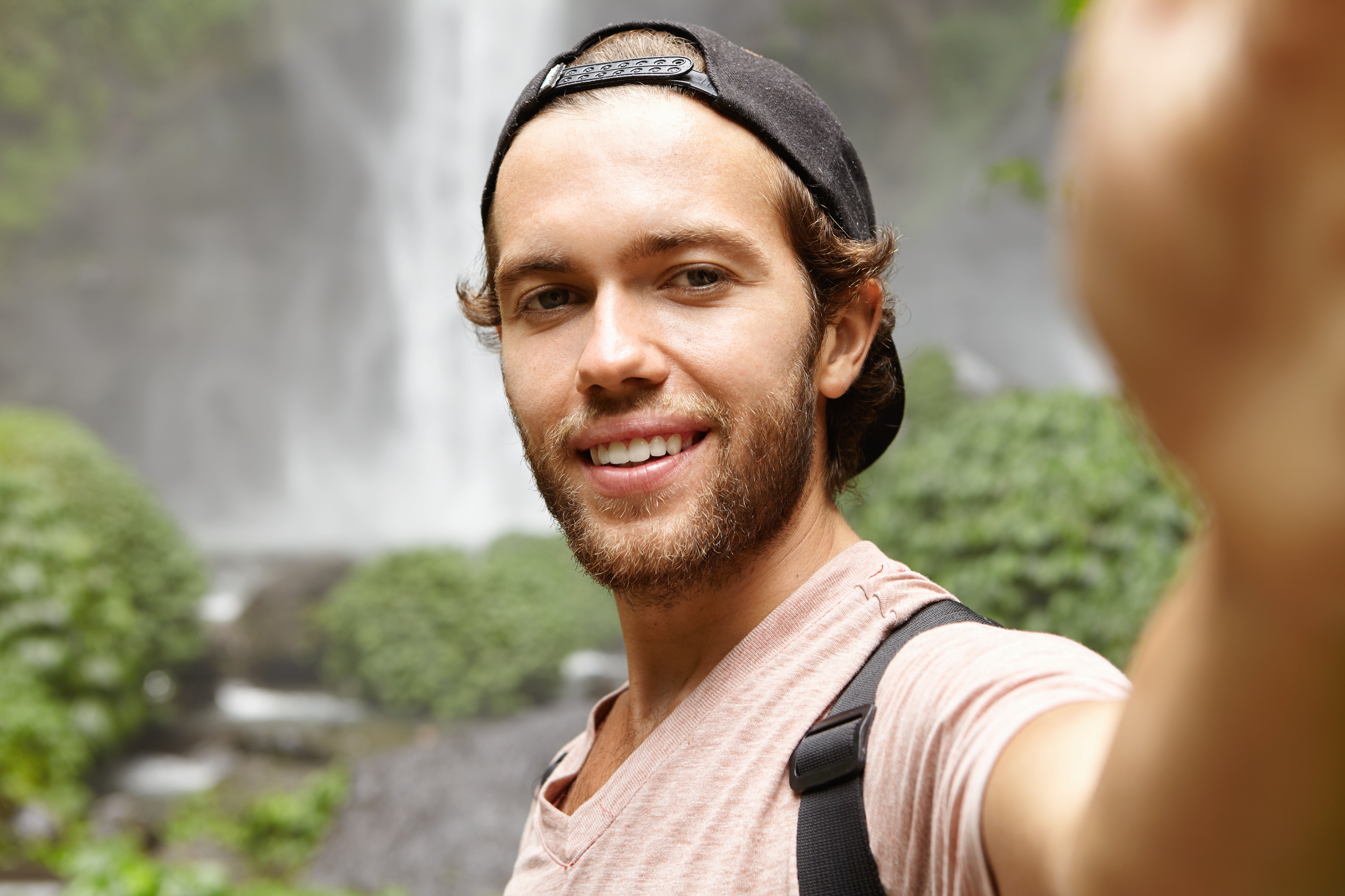 files/human-nature-tourism-handsome-young-traveler-snapback-smiling-joyfully-while-taking-selfie-posing-by-gorgeous-waterfall-rainforest.jpg